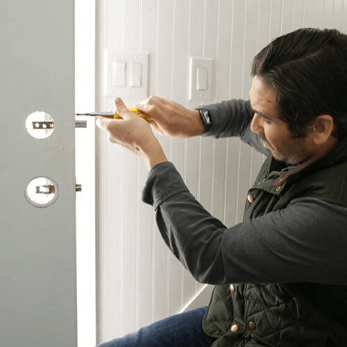 Man using tools to install door lock
